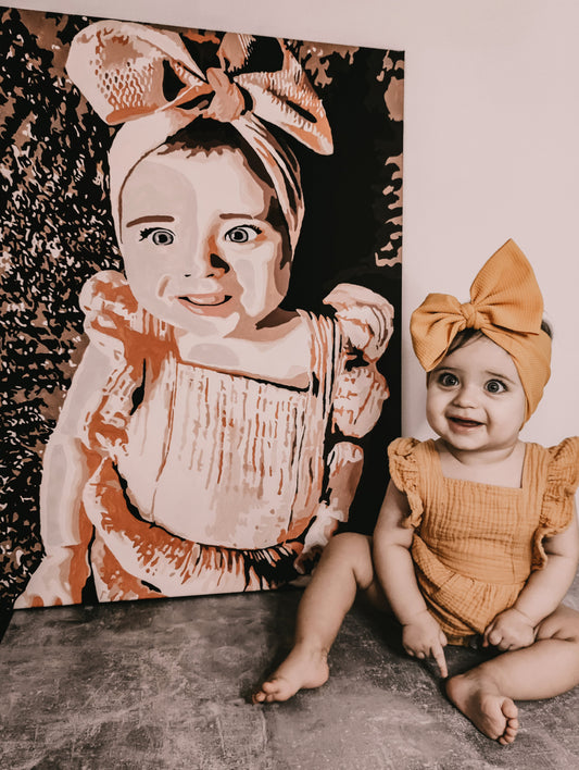 Babyfoto als schilderij naast de baby